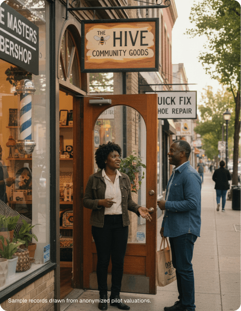 Two neighbors talking in the doorway of The Hive Community Goods, a storefront on a small-business main street